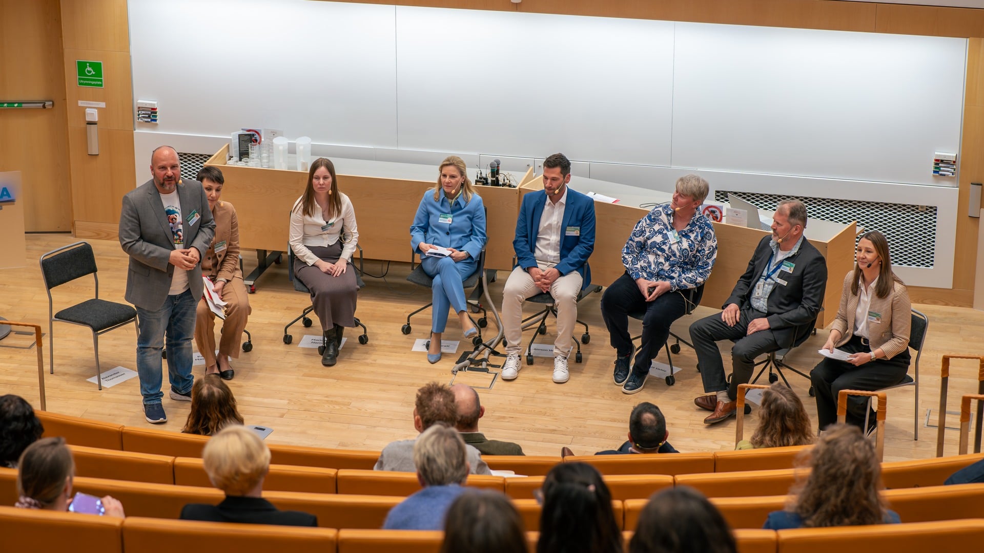 A group of people sitting on a stage in front of a crowd.