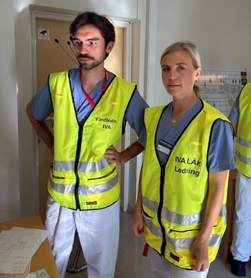 En man och en kvinna i gula v&auml;star st&aring;r bredvid varandra.