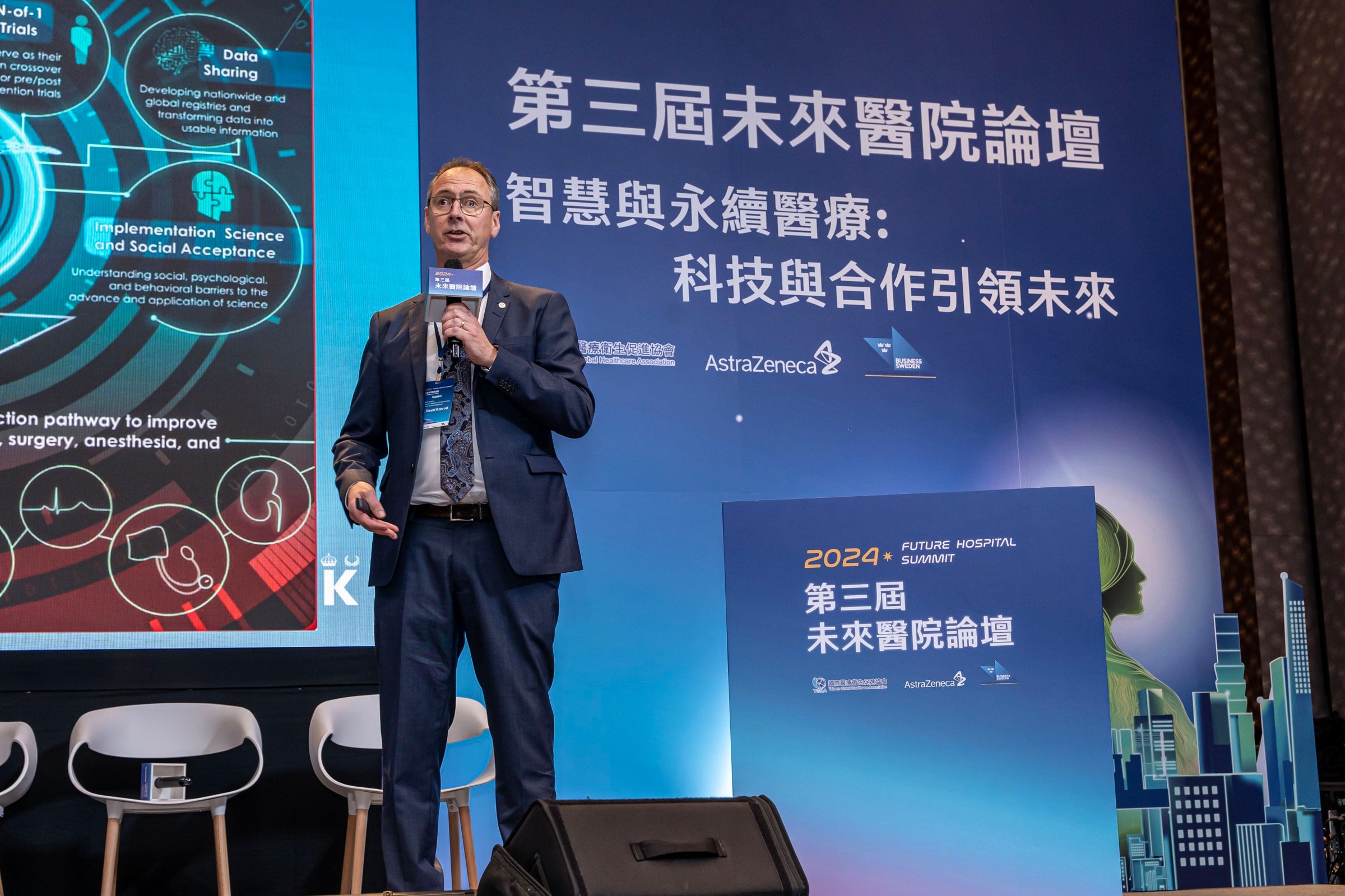 David Conrad standing on a stage giving a speech on the Future Hospital Summit 2024