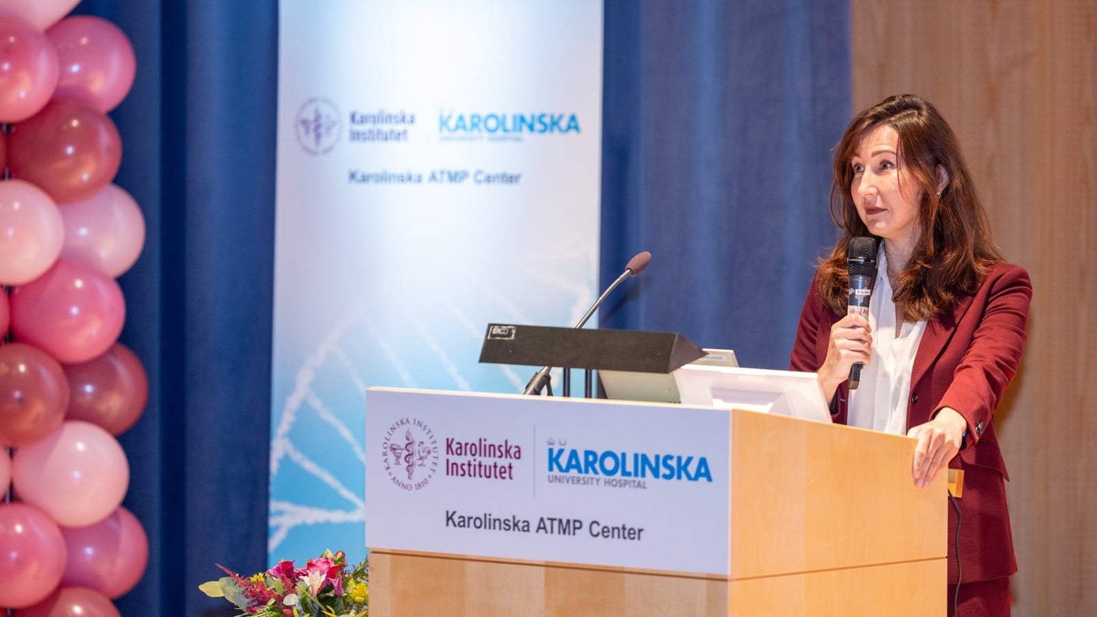 A woman standing at a podium with a microphone.